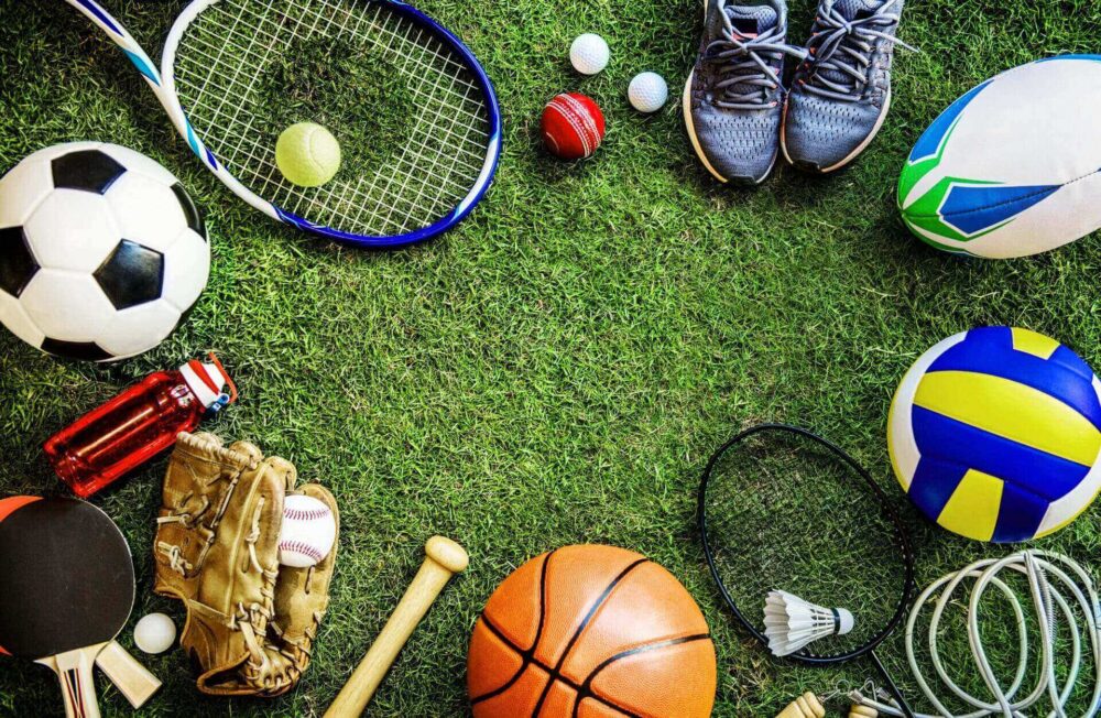 Assorted balls, racket and cleats on turf