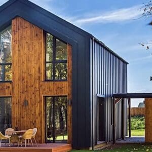 A house with two windows and a deck in the middle of it.